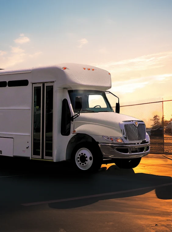 White shuttle bus parked next to a security fence at a prison near Davie